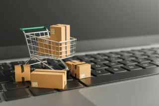 versand pakete in einem supermarkt-einkaufswagen auf einem notebook - online shopping!